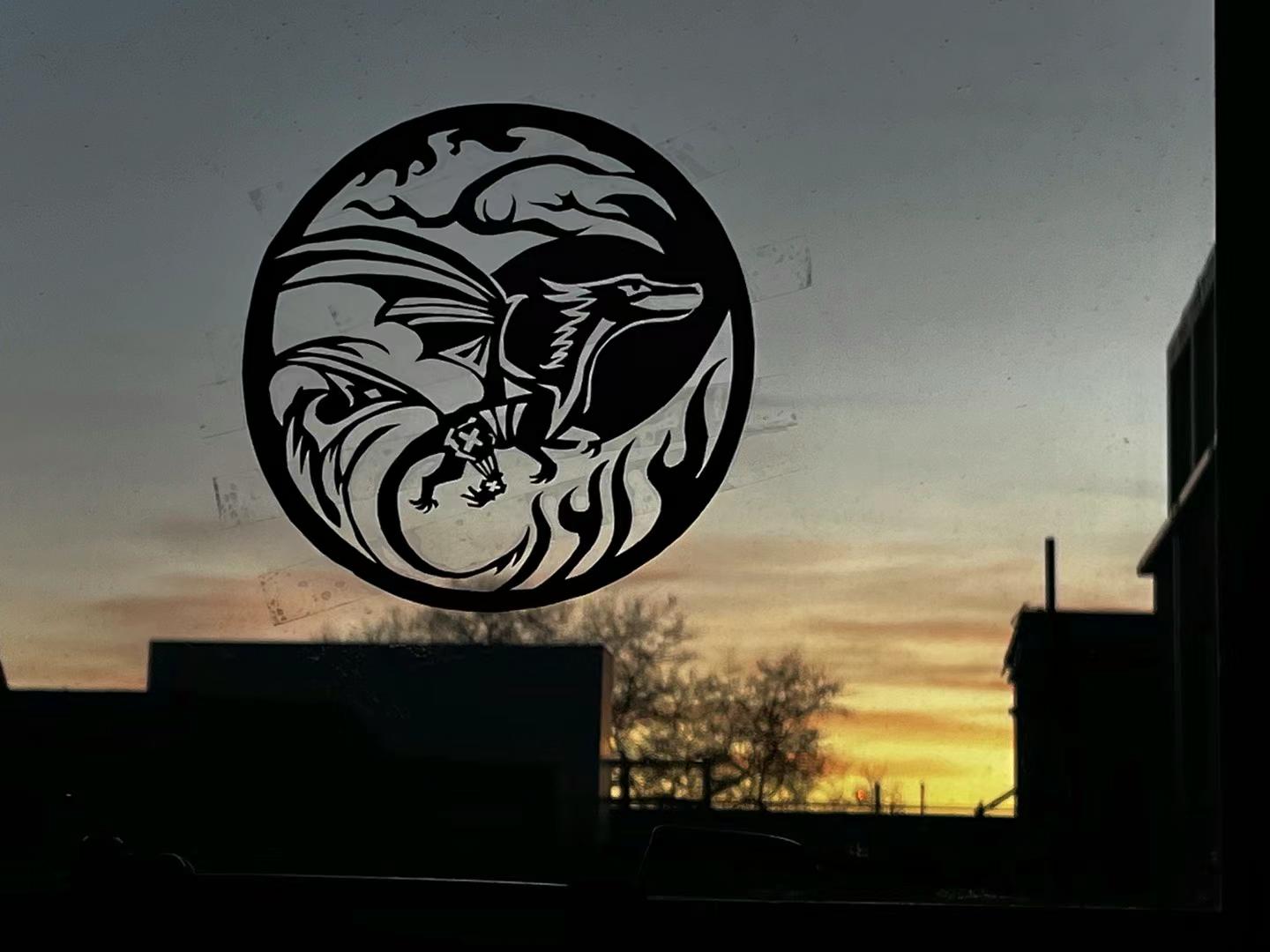 Paper-cut of a dragon against a sunset sky