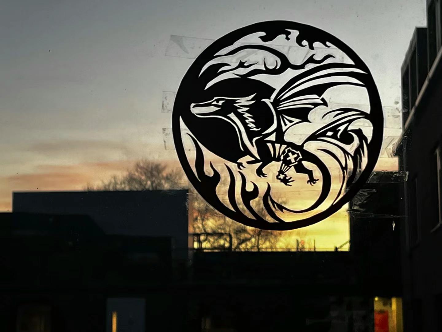 Paper-cut of a dragon against a sunset sky, different angle
